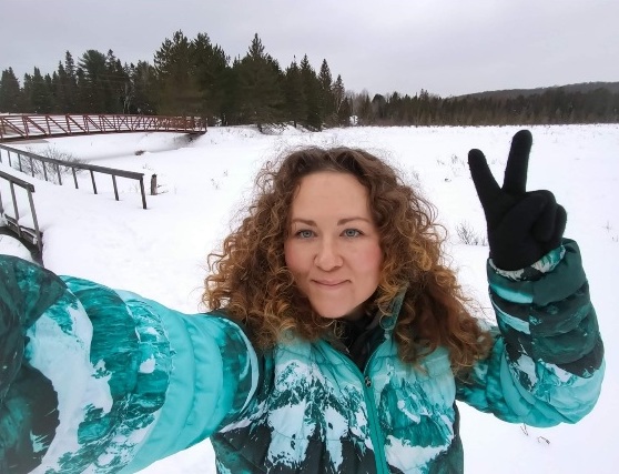 Kat Smiling in a winter Jacket with Snow all around